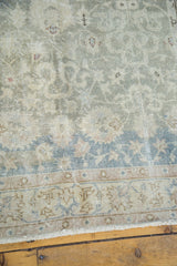 Distressed vintage Turkish rug border featuring abrashed seafoam green, beige, and soft blue.
