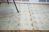 Distressed pile showcasing the blanched lattice pattern and light, airy tones of the vintage Oushak rug.