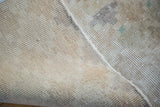 Reverse side of a blanched vintage Oushak rug, showing its hand-knotted foundation and subtle hues.