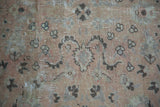 Faded cloudband design and soft neutral tones on a vintage Kayseri rug's pile.