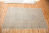Lower right, distressed Oushak rug with softened blanched grey tones and classic pattern.
