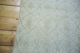 Close detail of a light modern Oushak rug edge, highlighting subtle distressed lattice lozenges.