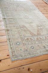 Vintage Oushak rug corner with fringe, sandy beige field, and muted geometric motifs.