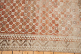 Geometric border design on a distressed Oushak rug with warm terracotta tones.