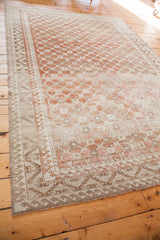 Decorative distressed Oushak carpet corner with muted coral lattice and geometric beige border.