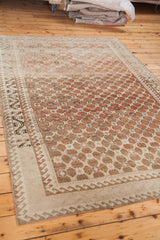 Distressed Oushak rug showing soft brown tone-on-tone lattice pattern and geometric border detail.