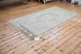 Vintage Oushak rug with decorative blanched aesthetic and faded bronze-peach motifs.
