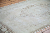 Blanched texture of a vintage Oushak carpet, with sun-faded bronze and peach patterns.
