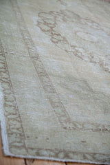 Detail of blanched vintage Oushak carpet with faded bronze curvilinear patterns.