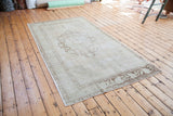 Vintage Turkish Oushak carpet corner, blanched aesthetic with faded bronze motifs.