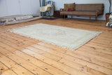 Blanched aesthetic of a vintage Turkish Oushak carpet, with sun-faded bronze medallion.