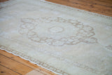 Blanched vintage Oushak carpet showing sun faded bronze and peach medallion details.