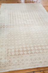 Decorative texture, softened beige and ivory harlequin lattice on distressed Oushak rug.