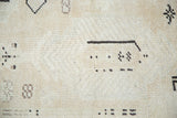Blanched ivory pile texture, scattered charcoal and silver abstract motifs on Oushak rug.