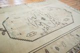 Faded ivory and blanched vintage Oushak carpet section with charcoal geometric patterns.
