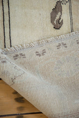Soft ivory pile, fringe, and hand-knotted ribbed foundation of a vintage Oushak rug.