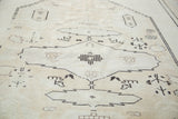 Textured vintage Oushak carpet pile showcasing abrash in ivory, beige, and charcoal geometric motifs.