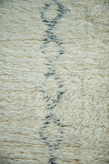 Plush ivory vintage Moroccan rug pile, highlighting blanched charcoal abstract pattern.