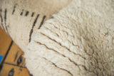 Shaggy natural ivory wool pile of the vintage Moroccan carpet.