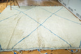 Vintage Moroccan carpet with thick ivory pile, chalk-sky blue lines, and tasseled edge.