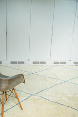 Vintage Moroccan carpet featuring pale ivory white shaggy pile and chalk-sky blue abstract lines.