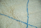 Pale ivory shaggy pile vintage Moroccan rug with chalk-sky blue abstract lines.