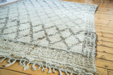 Shaggy fringe detail on a vintage Moroccan rug with blanched ivory and charcoal lattice.