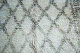 Vintage Moroccan carpet's shaggy ivory pile with organic charcoal grey lattice motif.