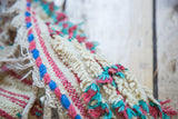 Textured ivory pile with woven hot pink and aqua blue edge detail of the Moroccan runner.