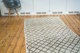 Textured vintage Moroccan rug with ivory field and charcoal lattice pattern.