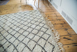 Textured ivory vintage Moroccan rug with minimalist charcoal lattice and natural fringe.