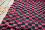Red and charcoal black checkered pattern with textured pile on vintage Moroccan rug.