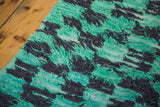 Furry, shaggy pile in an abstract mint green and charcoal pattern.