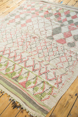 Faded grapefruit, green, ivory geometric lattice and striped border of Moroccan rug.