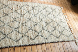 Fluffy ivory pile of a vintage Beni Ourain rug with charcoal lattice motif.