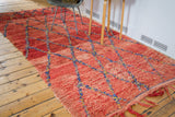Deep cherry red abrashes on vintage Moroccan rug with royal blue lattice and fringe.