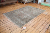 Distressed Oushak carpet with faded peach, coral, and ivory patterns, showcasing soft texture.