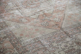 Soft peach and beige faded motifs on a distressed Oushak rug.