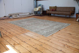 Distressed vintage Oushak carpet featuring soft peach, ivory, and beige ornate patterns.