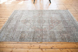 Distressed Oushak rug lower border with soft peach and ivory geometric motifs.