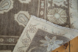 Vintage Oushak rug corner revealing hand-knotted foundation, fringe, and pale mint, ivory geometric motif.