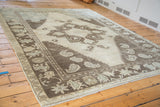 Whimsical geometric border and fringe of a vintage Oushak carpet in charcoal, silver, and mint.