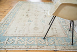 Pale aqua border with reciprocating motif, platinum ivory field, and fringe of a vintage Oushak rug.