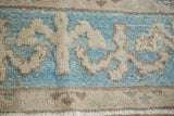 Vintage Oushak rug's pale aqua blue border, reciprocating platinum ivory motif, hand-knotted pile.