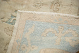 Vintage Oushak rug reverse, revealing pale aqua border's reciprocating motif and fringe.
