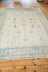 Pale aqua border with reciprocating motif, platinum ivory field, and fringe of vintage Oushak rug.