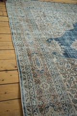 Textured border detail of distressed Oushak carpet with blanched ivory and soft blue patterns.