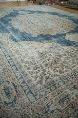 Distressed Oushak carpet's faded sky blue and ivory traditional floral motifs and texture.