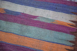 Textured tribal stripes on the vintage Moroccan kilim in orange, purple, gray, and ivory.