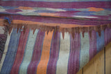 Detail of vintage Moroccan kilim's reversible geometric stripes and textured woven edge.